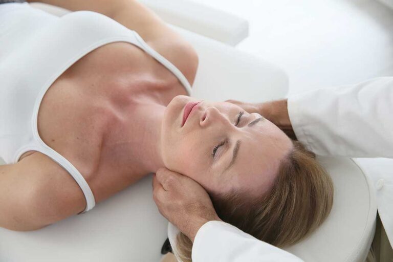 A person sleeping comfortably on their side with a pillow between the knees on a neatly made bed.
