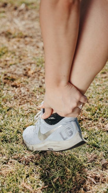Person walking while a clinician observes foot placement, pelvic position, and spinal posture from the side.